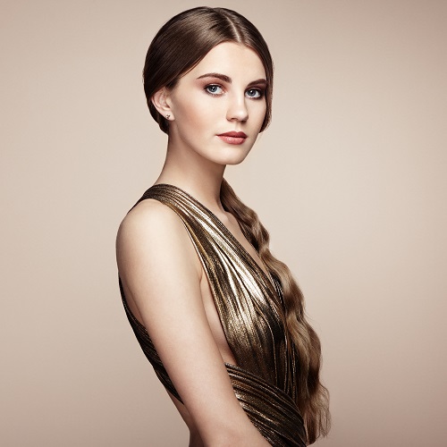 Fashionable portrait of a young beautiful Ukrainian woman in a gold dress